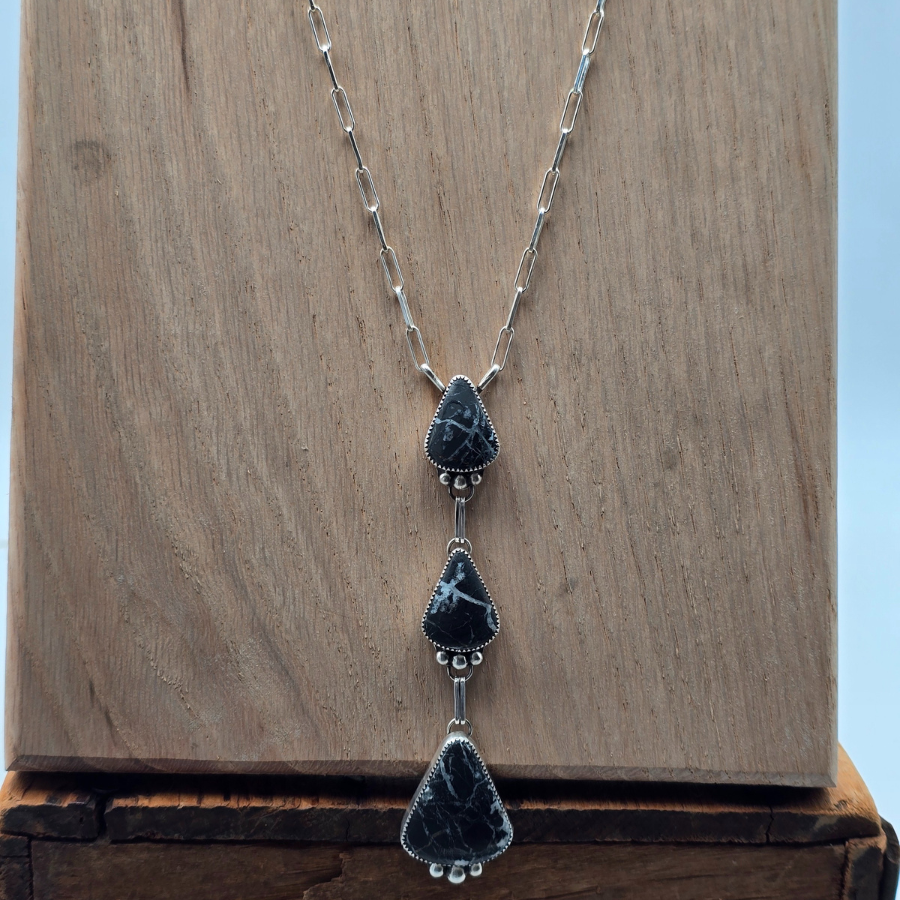 Necklace with blue teardrop-shaped pendants on a wooden surface